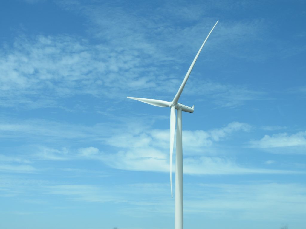 wind turbine against a cloudy blue sky
