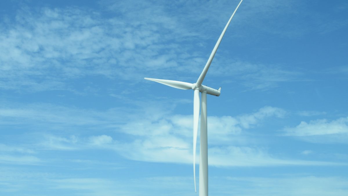 wind turbine against a cloudy blue sky